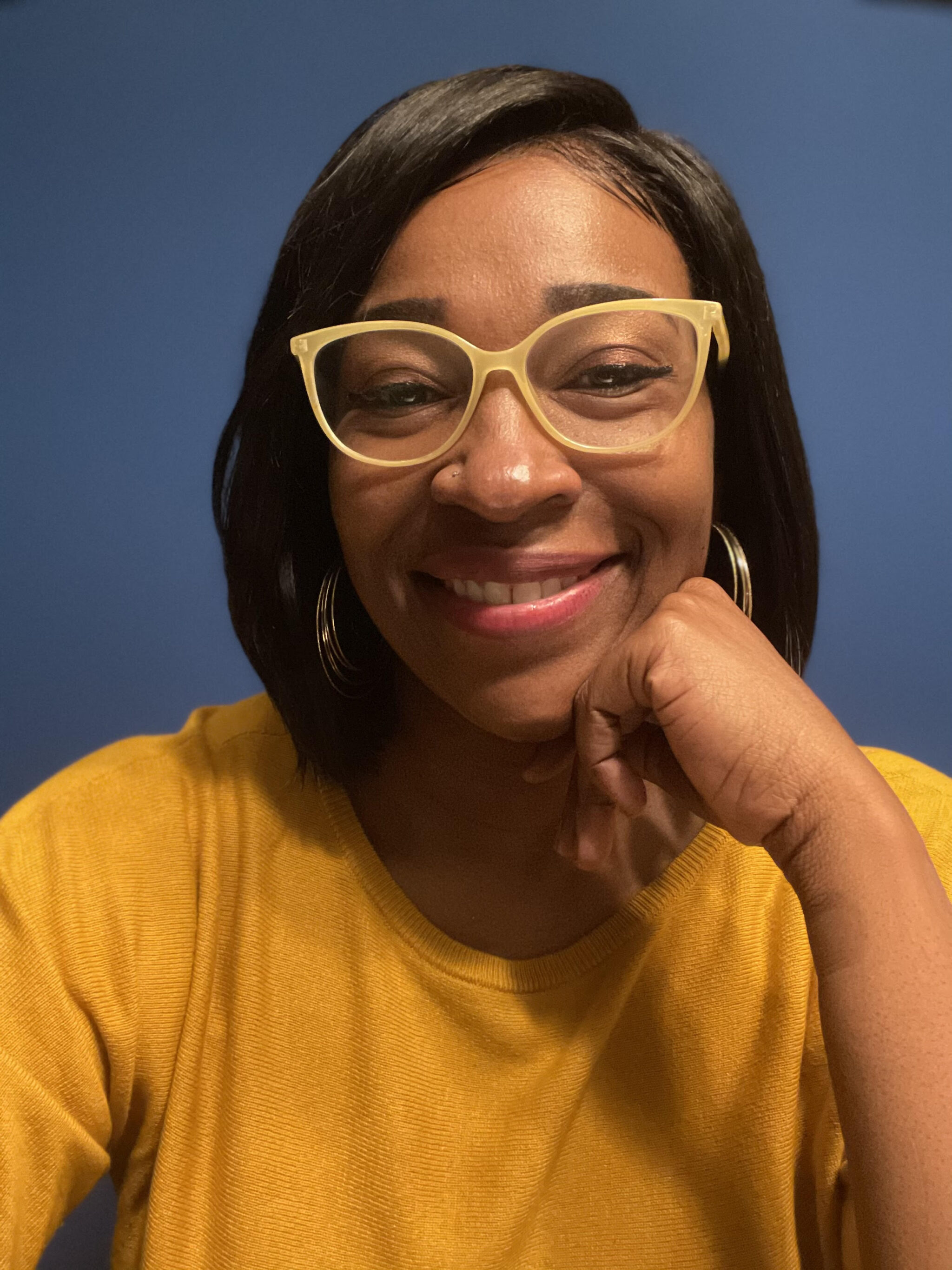 Woman in glasses in a yellow shirt on a blue background