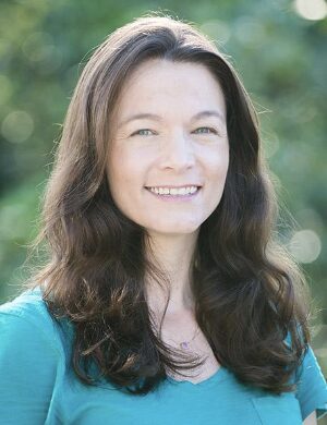 Woman with long hair wears a green top