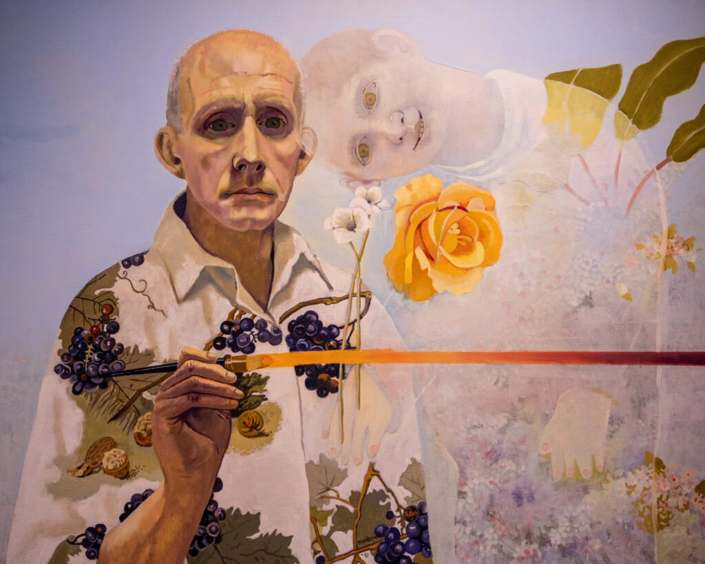 A photo of a colorful painting. On the left center is a masculine-presenting figure with a blank expression. They hold a paintbrush in their right hand that connects to a streak crossing over to the right side of the painting. On the center right is a faded, childlike figure smiling with their neck bent severely. Two flowers hover between the two figures.