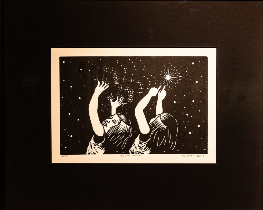 A photo of black-and-white art. The work shows two illustrated children gesturing energetically to a starry sky. The child on the left makes a sign language sign for "stars", and the child on the right signs the singular "star".