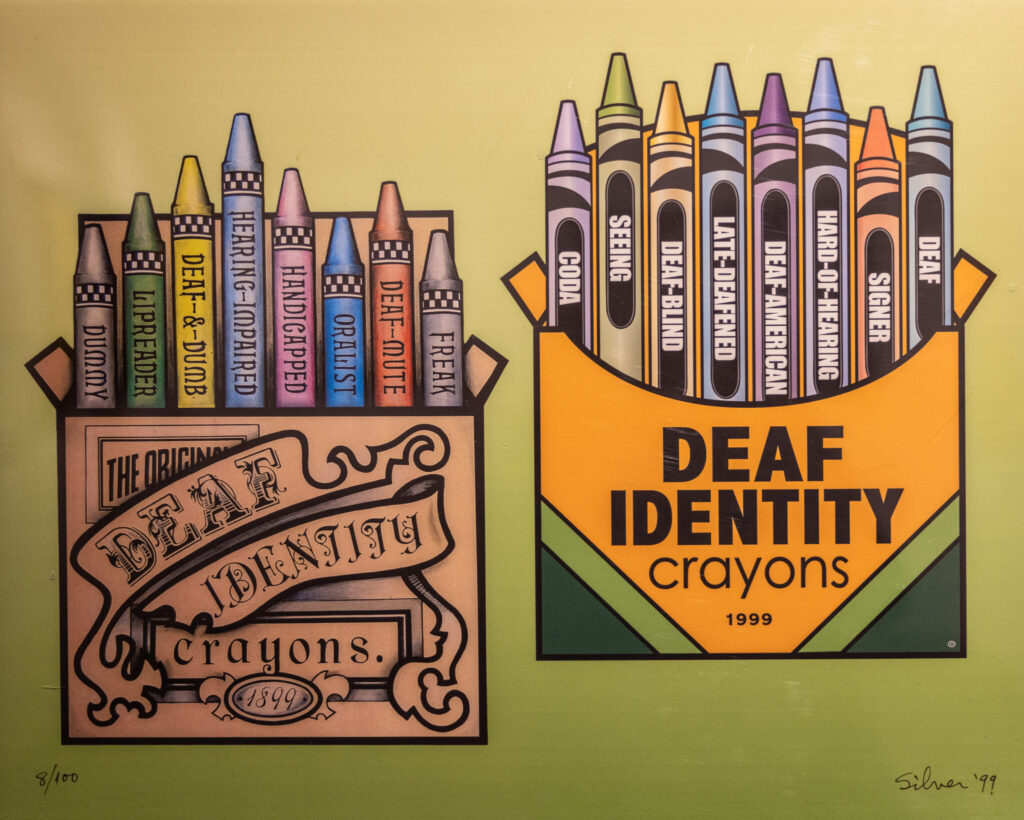 A photo of a painting showing two illustrated boxes of crayons. The box on the left has an old-fashioned design, and says "Deaf Identity Crayons, 1899". The individual crayons are labeled with negative terms associated with Deaf people. The box on the right is styled like a typical children's set, and says "Deaf Identity Crayons, 1999". The crayons are labeled with positive terms.