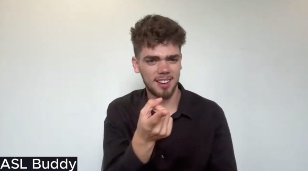 Man in a black shirt points to the camera. The text "Deaf buddy" appears at the bottom left of the image.