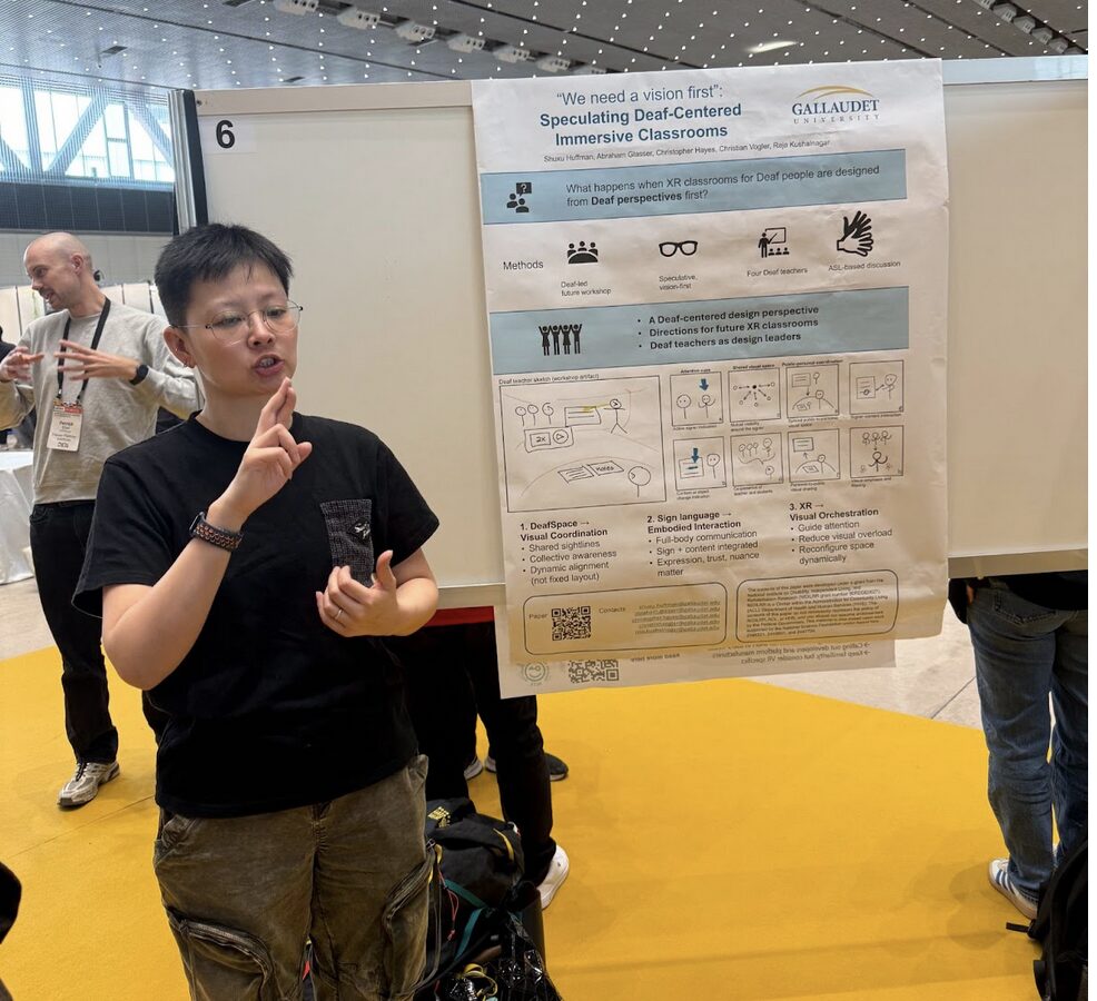 A person stands next to a scientific poster in a conference hall.