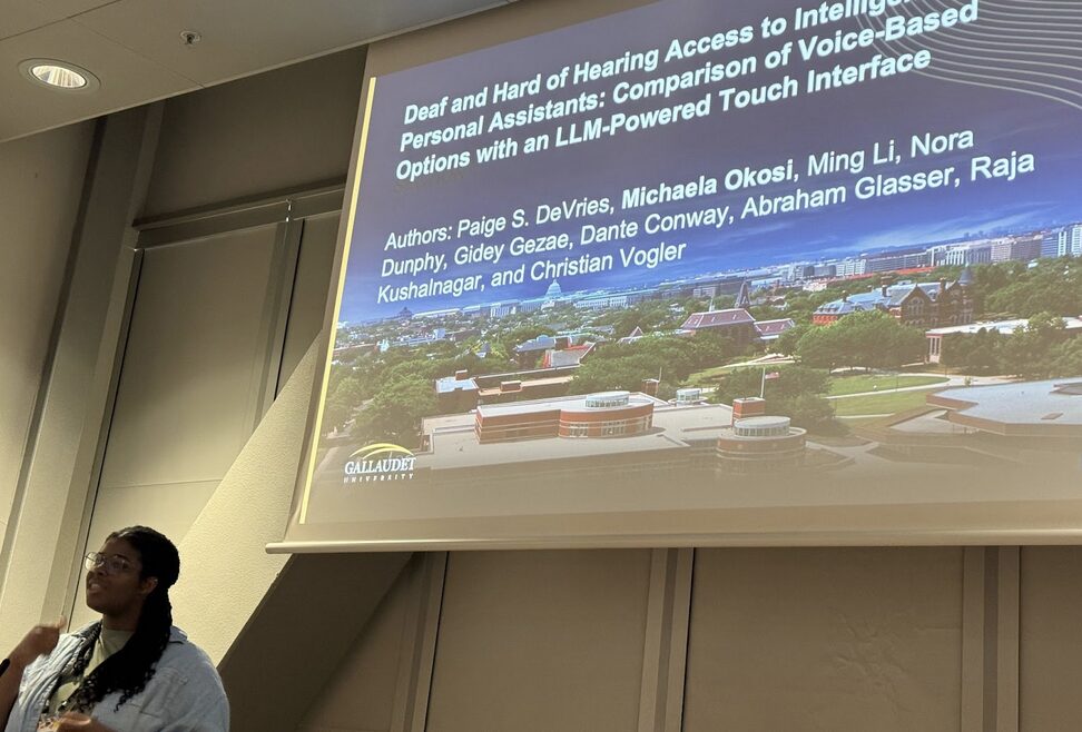 A person's head is in the lower left corner of the image, which is dominated by a large screen with text.